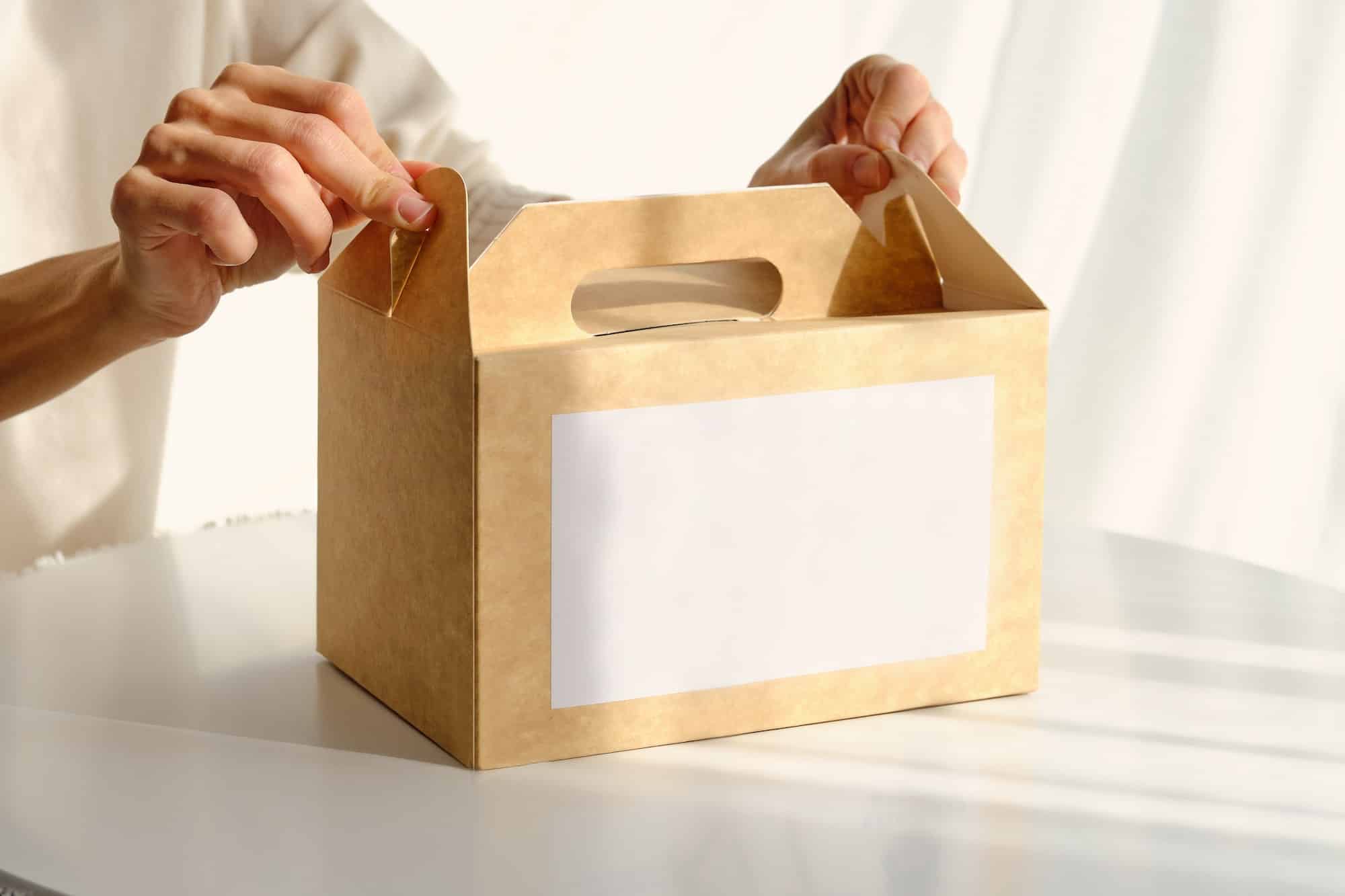 Woman packing box with food placed on table